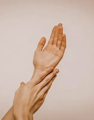 hand squeezing a lemon into a glass of water